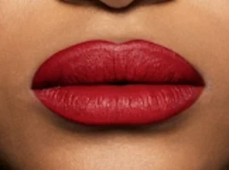 Fenty Beauty Stunna Lip Paint Uncensored, an opaque red, on medium skin
