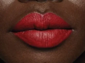 Fenty Beauty Stunna Lip Paint Uncensored, an opaque red, on deep skin